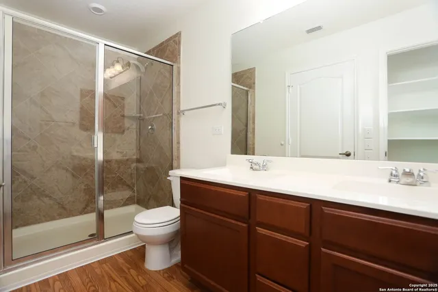 a bathroom with a double vanity sink toilet and shower