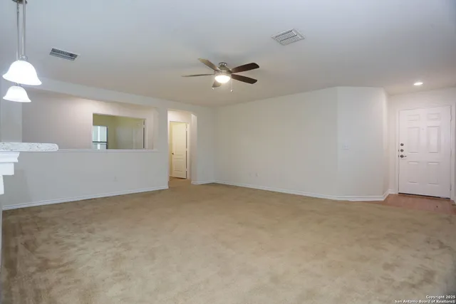 an empty room with fan and windows
