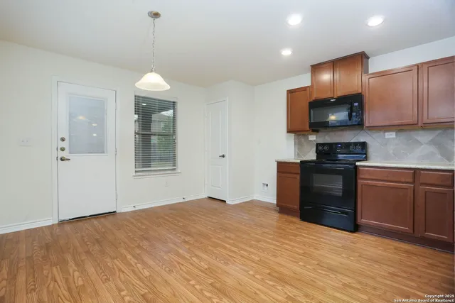 a kitchen with stainless steel appliances granite countertop a stove a sink and a refrigerator with wooden floor