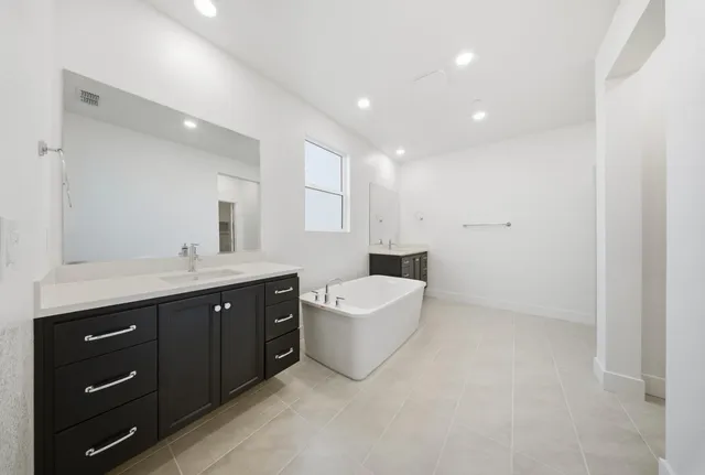 a spacious bathroom with a double vanity sink a mirror and a bathtub