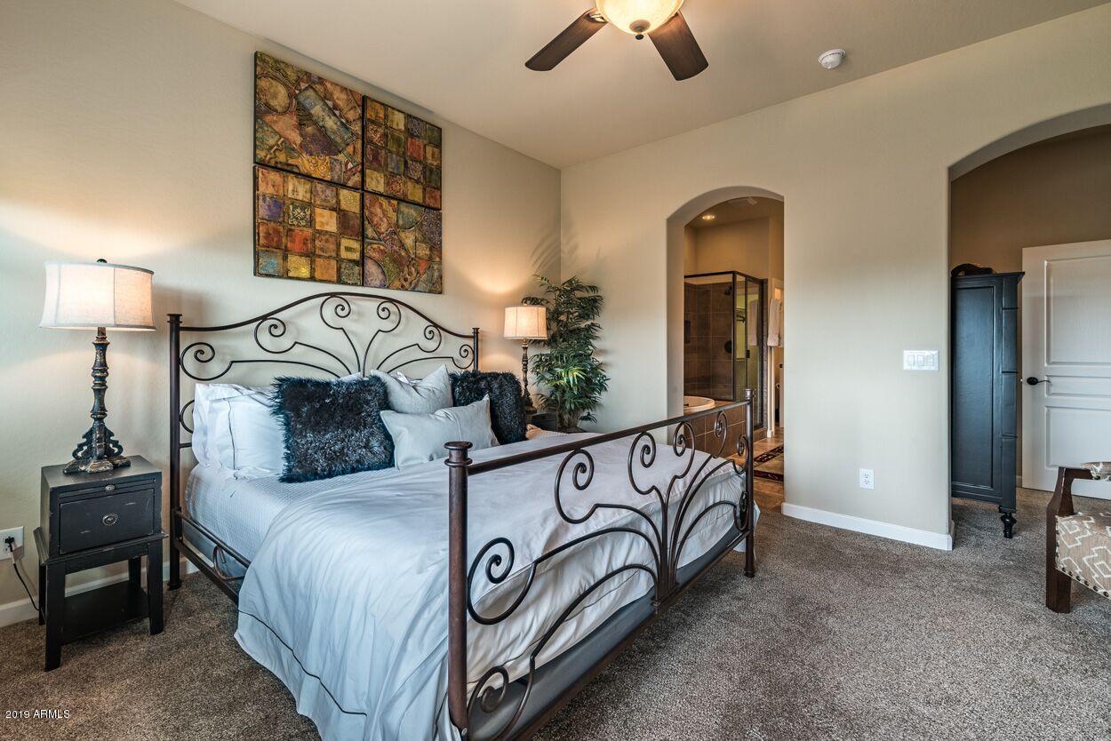 20750 North 87th Street, Unit 1123 Scottsdale, AZ 85255 - Photo 18 of 32 a bedroom with a bed and a chandelier