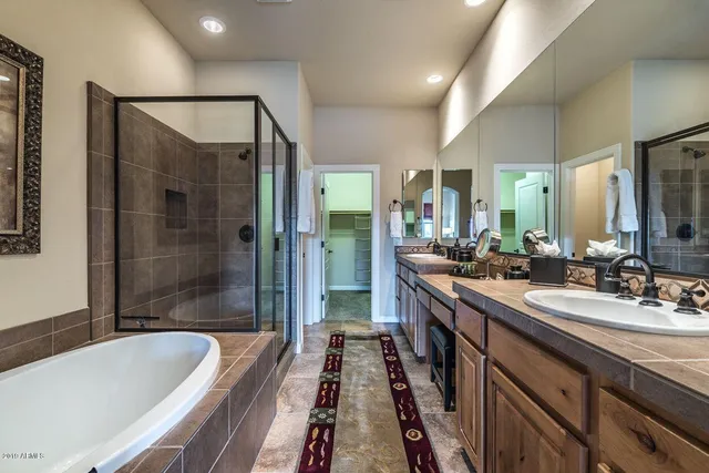 a bathroom with a bathtub shower sink and mirror