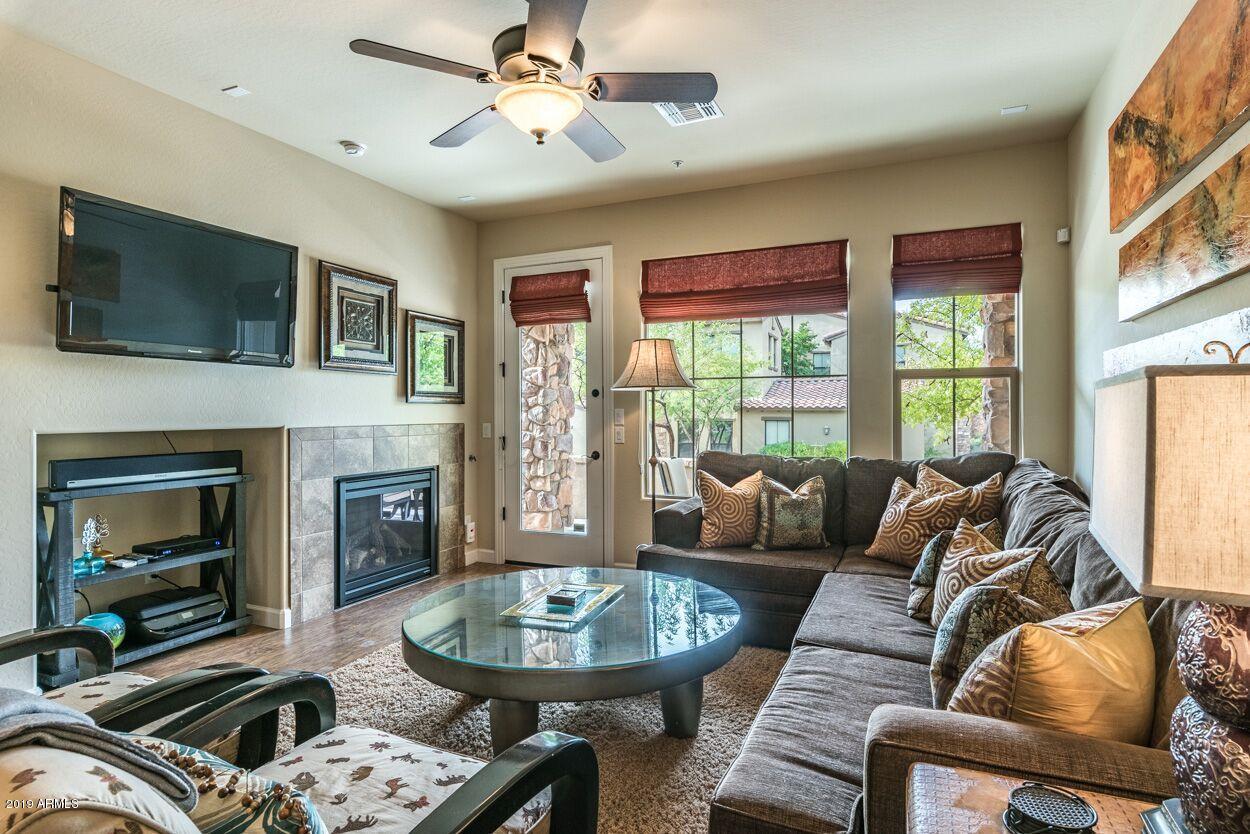 20750 North 87th Street, Unit 1123 Scottsdale, AZ 85255 - Photo 5 of 32 a living room with furniture a fireplace and a flat screen tv