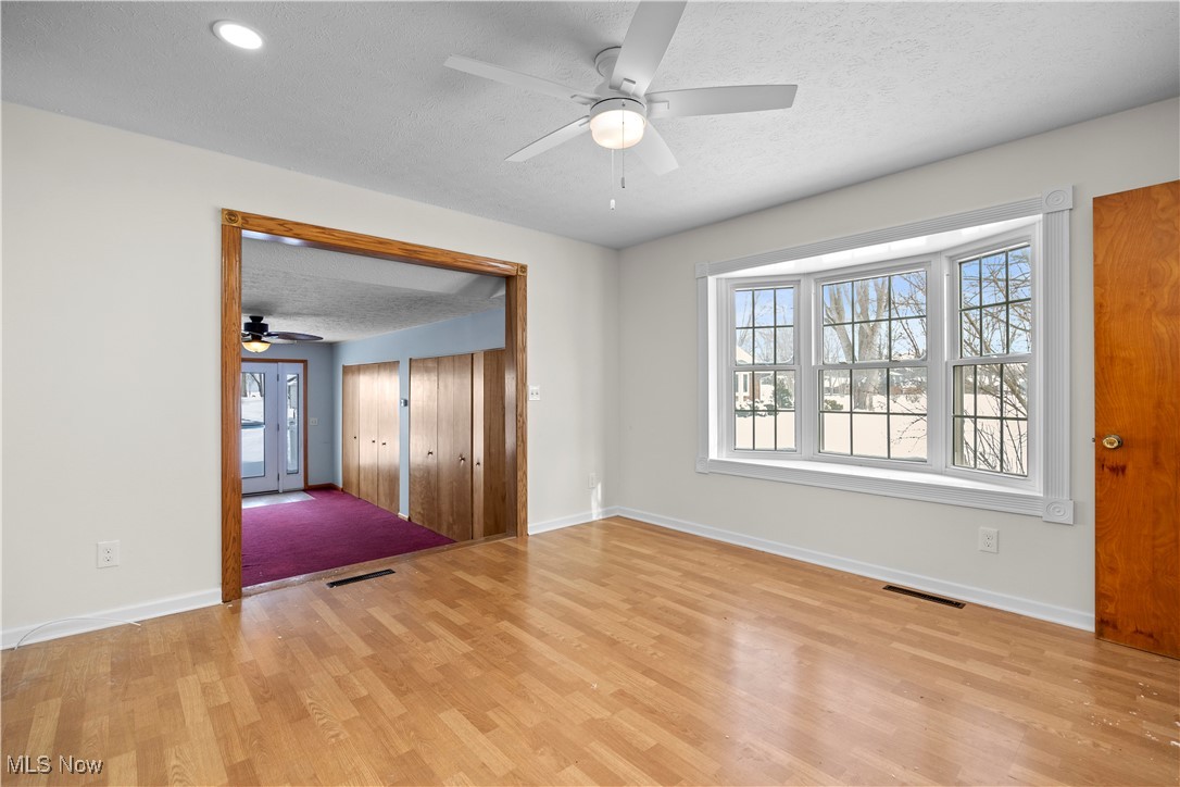 14015 West Lake Road Vermilion, OH 44089 - Photo 20 of 50 Unfurnished room featuring a textured ceiling, a ceiling fan, and light wood-style flooring