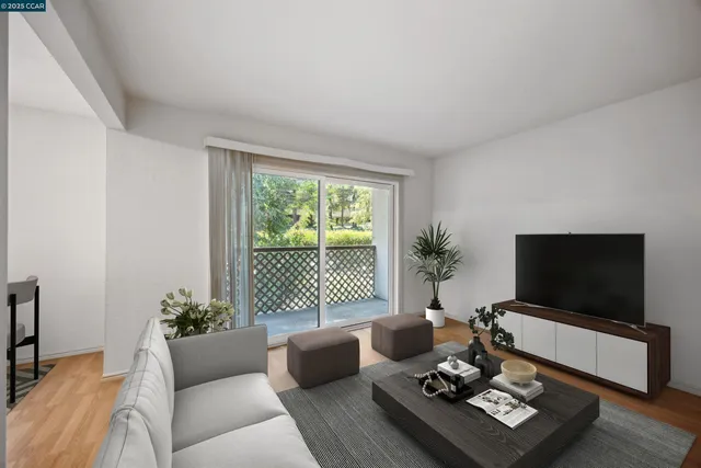 a living room with furniture a flat screen tv and a window