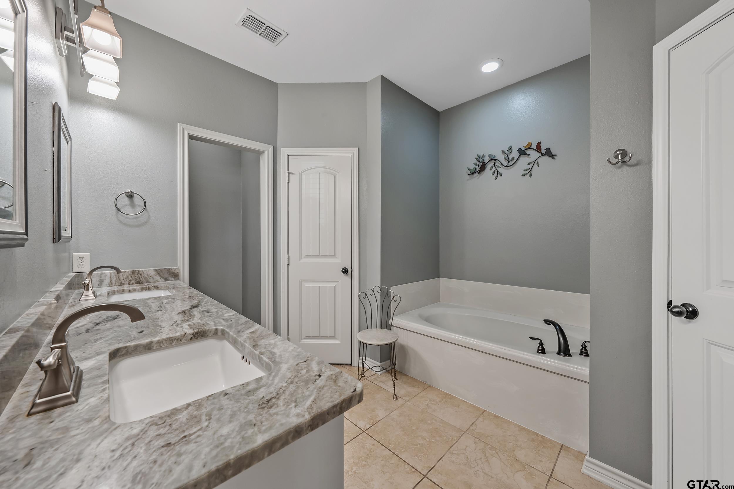 3056 Cornerstone Trail Tyler, TX 75701 - Photo 12 of 24 a bathroom with a granite countertop sink a bathtub and shower