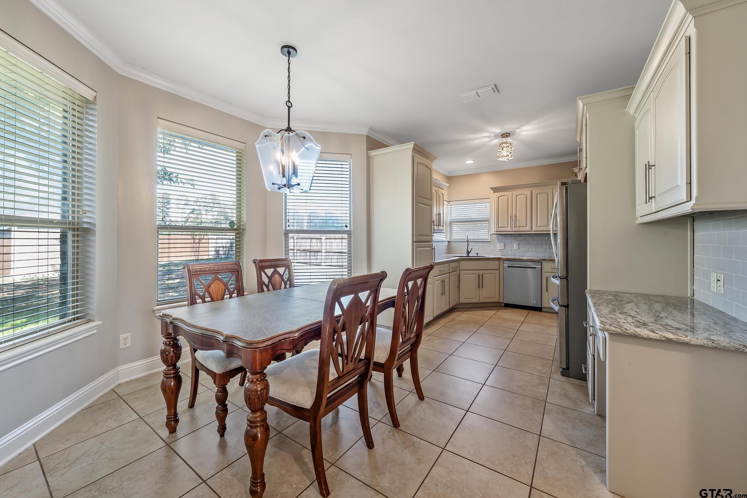 3056 Cornerstone Trail Tyler, TX 75701 - Photo 22 of 24 a dining hall with stainless steel appliances granite countertop a stove a sink a dining table and chairs