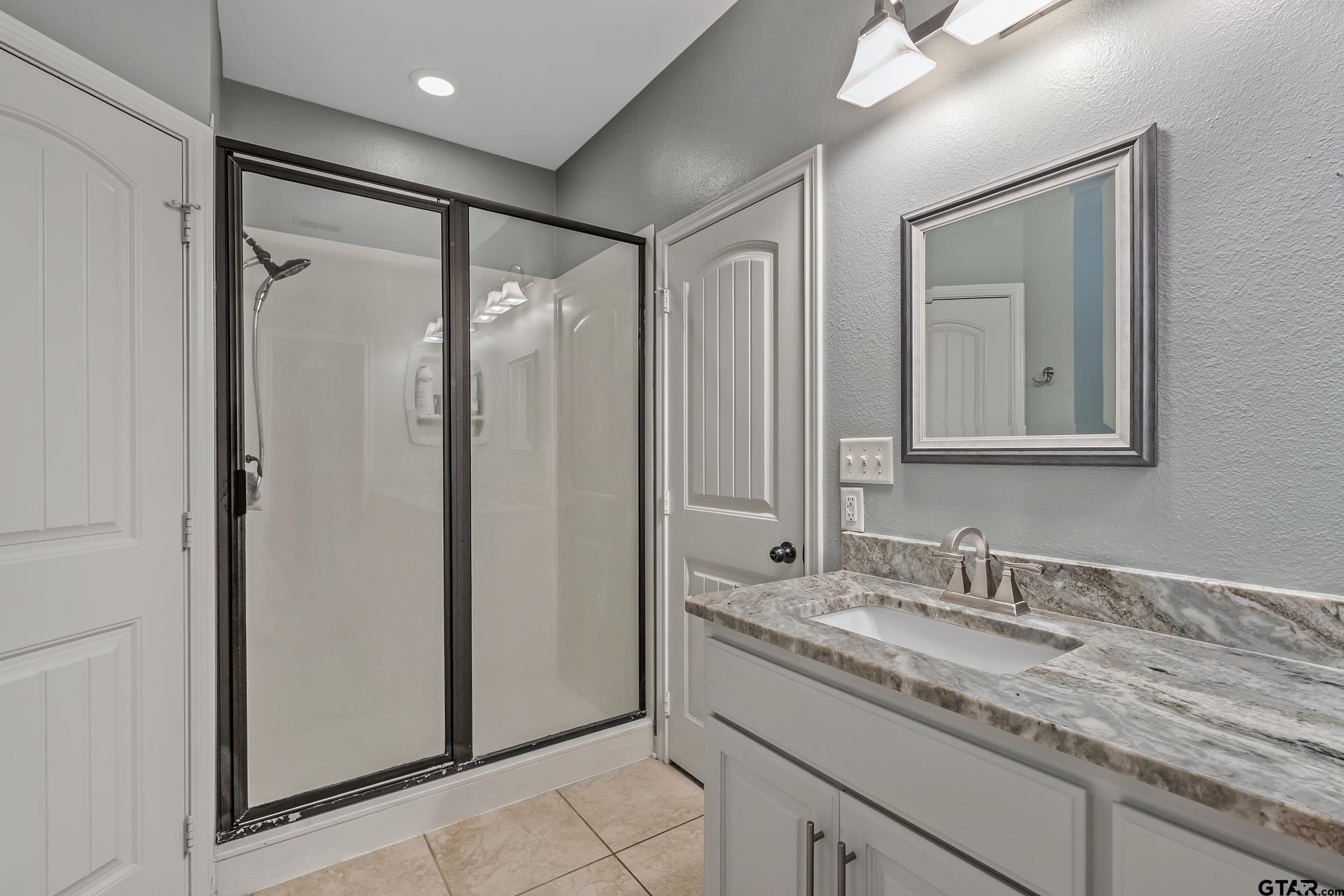 3056 Cornerstone Trail Tyler, TX 75701 - Photo 9 of 24 a bathroom with a granite countertop sink mirror and double