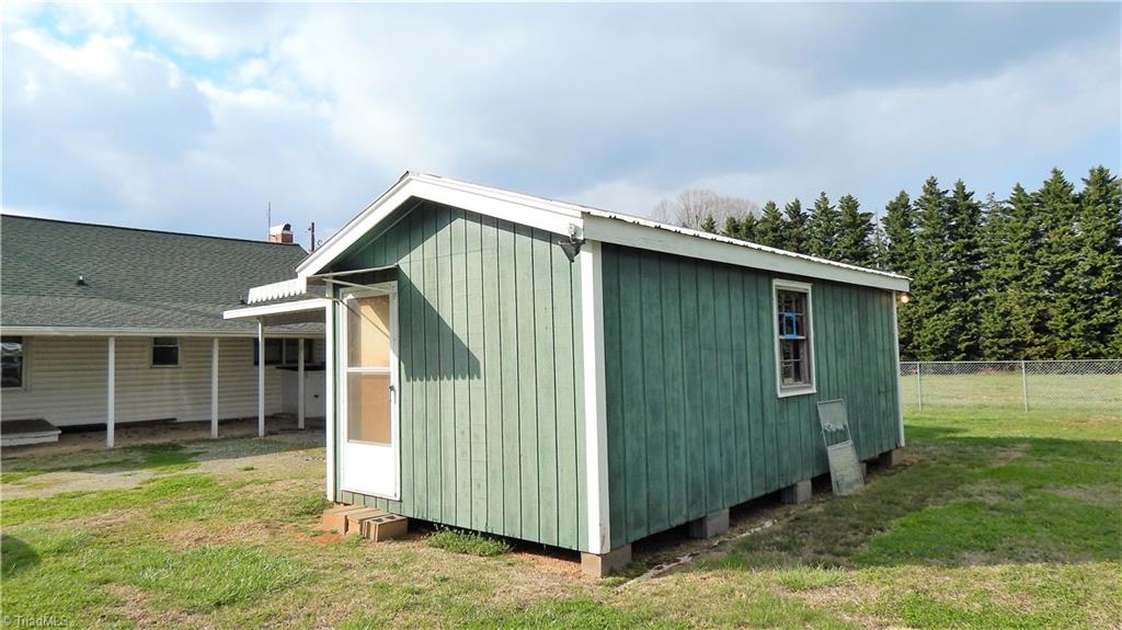 6719 Coltrane Mill Road Greensboro, NC 27406 - Photo 22 of 26 Workshop/storage Bldg with electricity & storm door & windows!