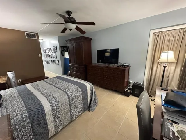 a bedroom with a bed and a flat tv screen on a dresser