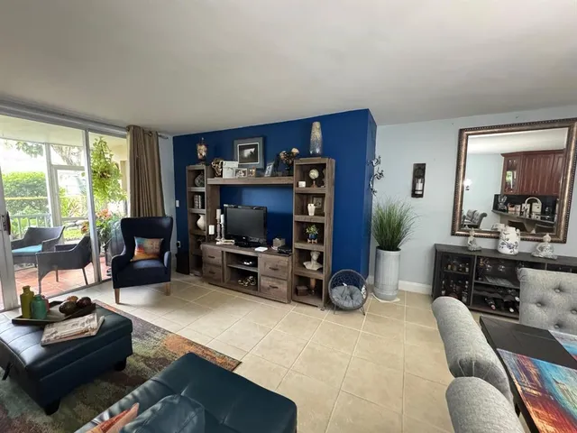 a dining room with furniture a chandelier and kitchen view