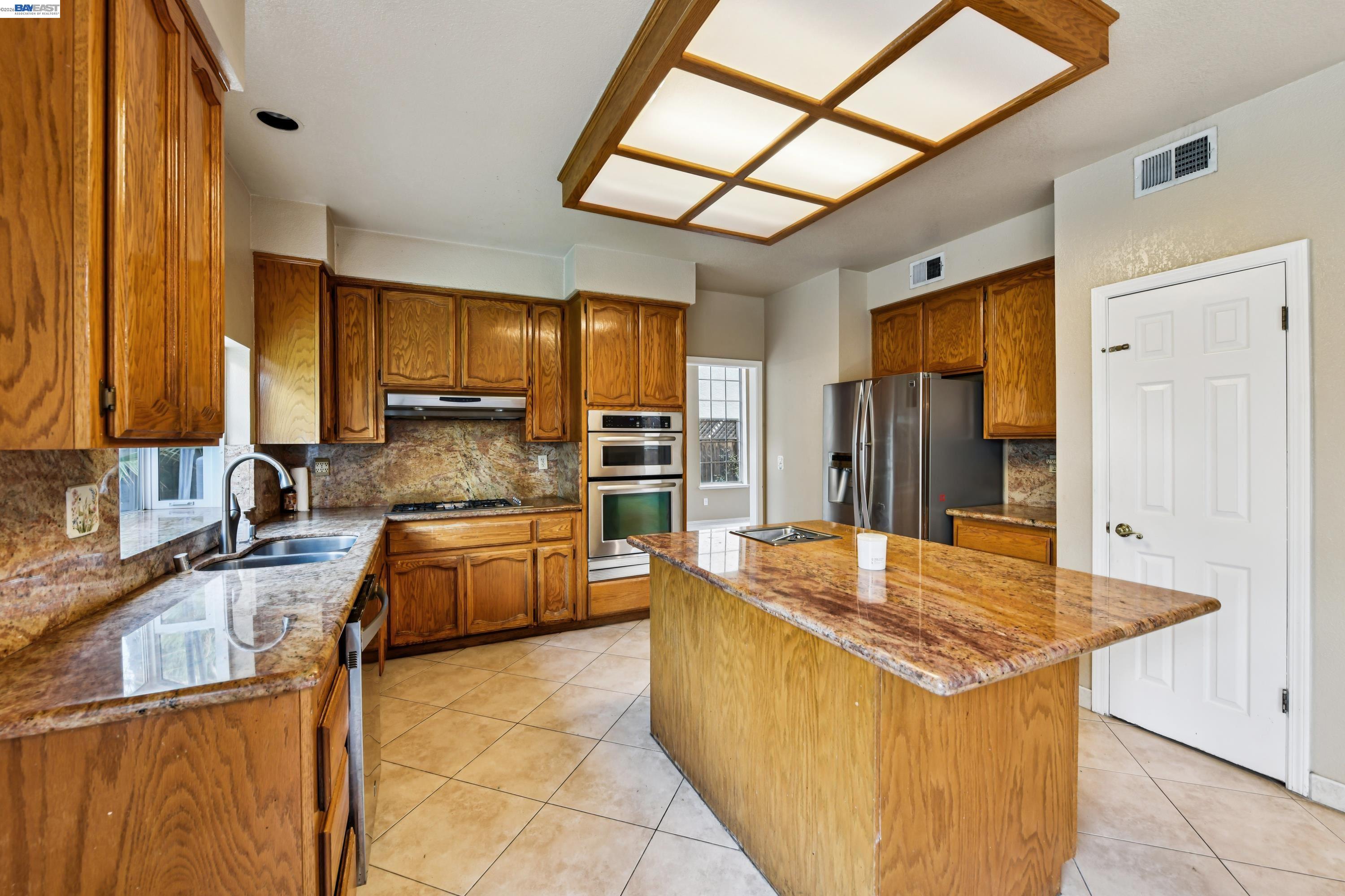 110 Conductor Way Folsom, CA 95630 - Photo 11 of 27 a large kitchen with kitchen island granite countertop a sink and refrigerator