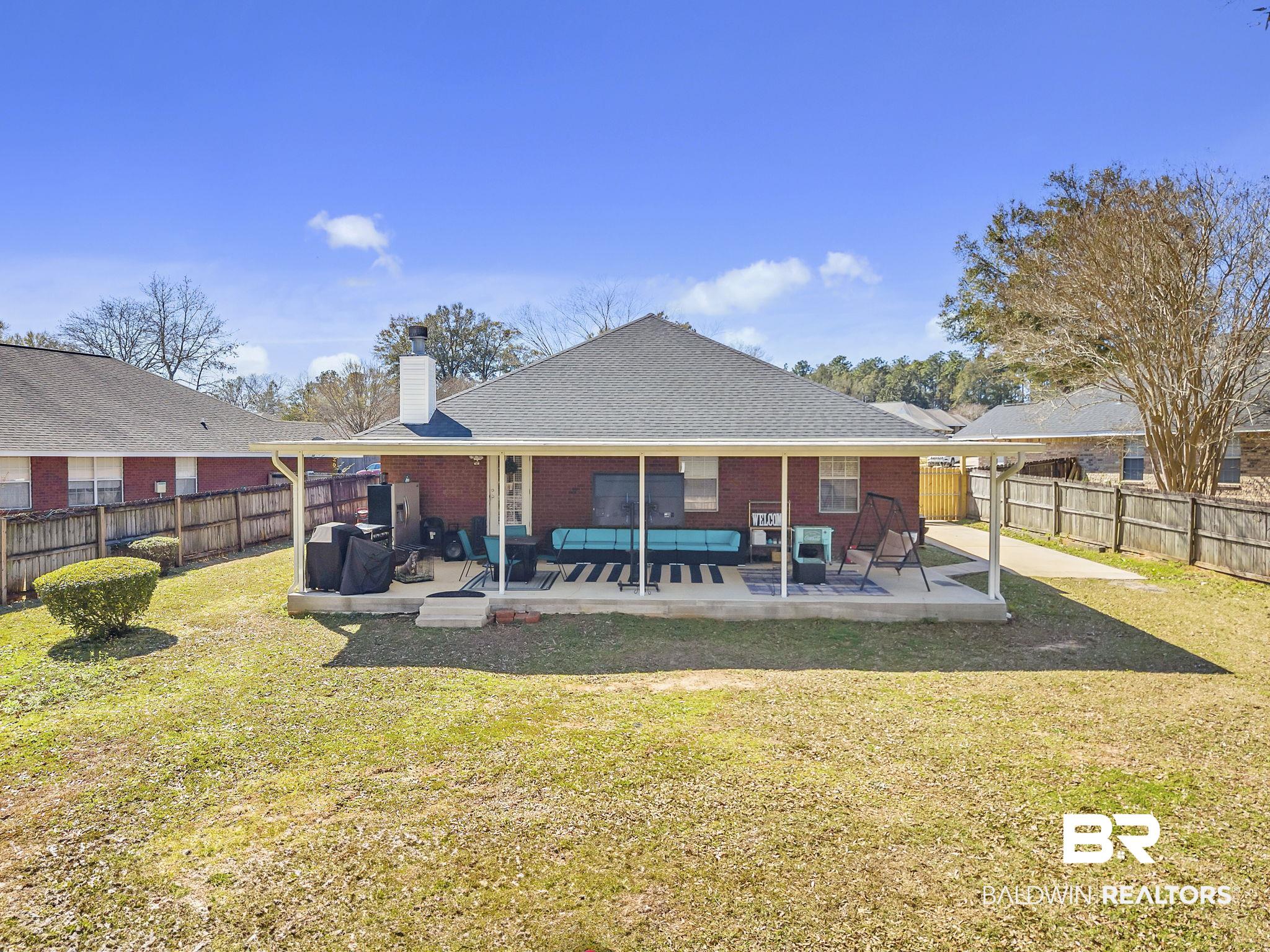 11103 Pontchartrain Loop Daphne, AL 36526 - Photo 28 of 29 Rear view of property featuring a patio, a yard, a fenced backyard, and brick siding