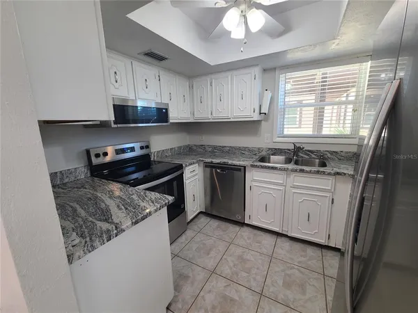 a kitchen with a stove sink and cabinets