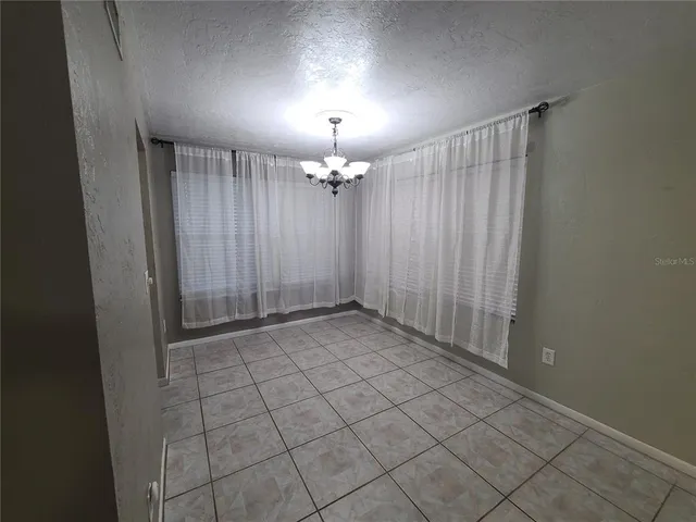a view of a livingroom with a chandelier fan and window