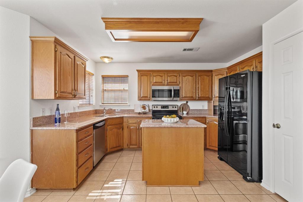 623 Madison Place Sherman, TX 75092 - Photo 11 of 37 a kitchen with a sink a counter top space cabinets and stainless steel appliances