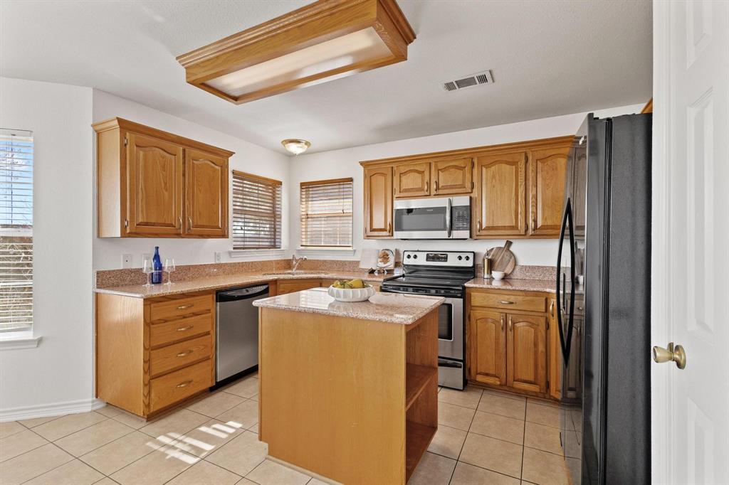 623 Madison Place Sherman, TX 75092 - Photo 10 of 37 a kitchen with stainless steel appliances granite countertop a sink stove and refrigerator