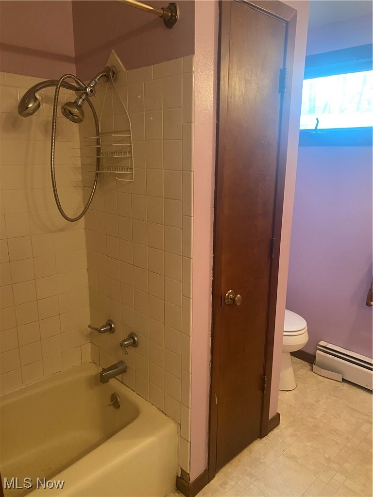 7316 Risden Road Vermilion, OH 44089 - Photo 18 of 22 Bathroom featuring tiled shower / bath combo, toilet, and a baseboard heating unit