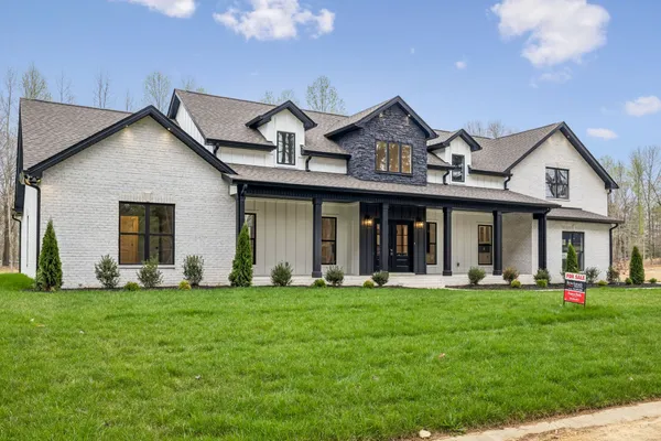 a front view of a house with a garden and yard