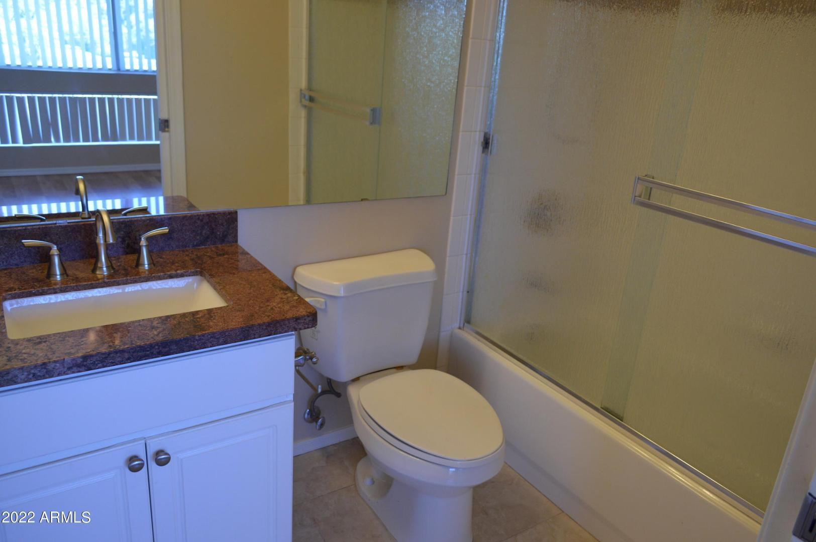 1701 East Colter Street, Unit 454 Phoenix, AZ 85016 - Photo 31 of 40 a bathroom with a sink a toilet and a mirror