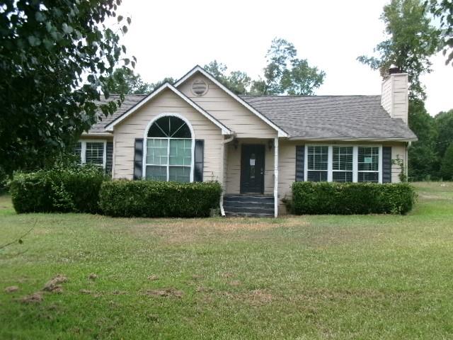 a front view of a house with yard and green space
