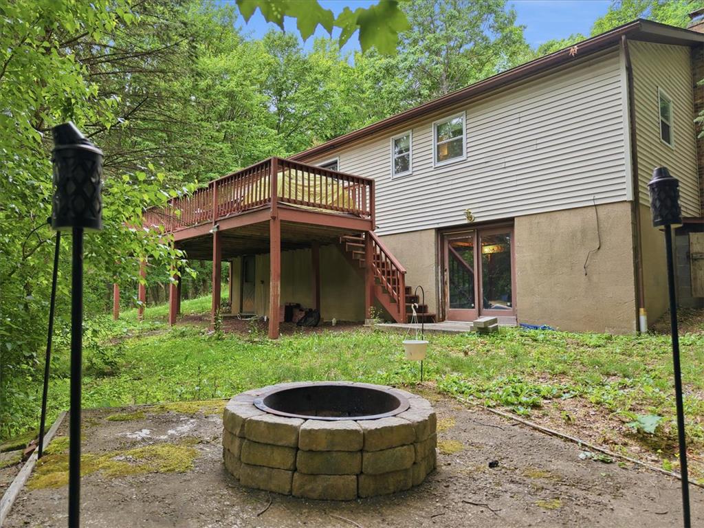 520 Highland Hill Road Jim Thorpe, PA 18235 - Photo 62 of 83 An inviting backyard retreat features a cozy stone fire pit and a private deck overlooking verdant surroundings.
