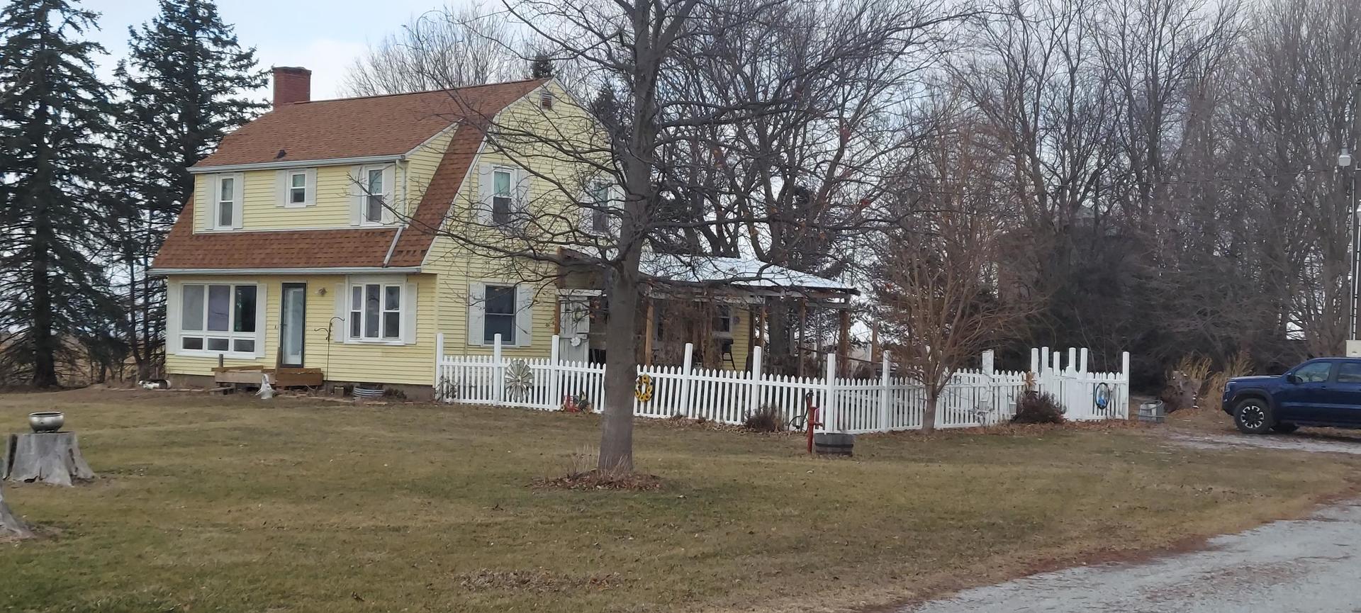 a view of a white house with a large tree in front of it