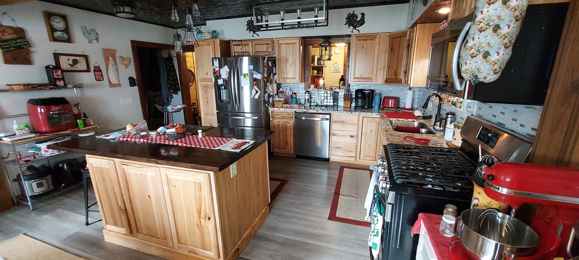 1640 170th Avenue Reynolds, IL 61279 - Photo 8 of 33 a kitchen with stainless steel appliances kitchen island granite countertop a refrigerator a stove a sink and a dining table with wooden floor