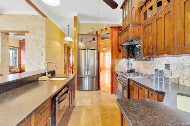 a kitchen with stainless steel appliances granite countertop a sink stove and refrigerator