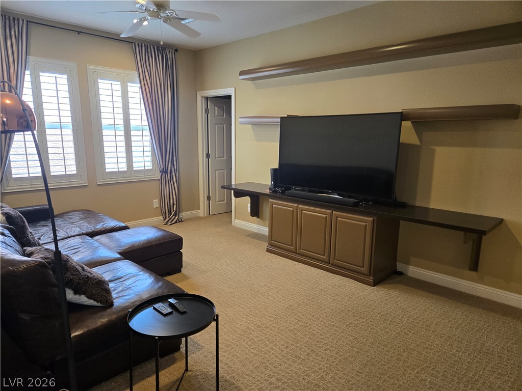 3144 Whitfeild Avenue Henderson, NV 89044 - Photo 44 of 55 Relaxation awaits in this cozy living space with carpeted flooring and elegant window shutters.