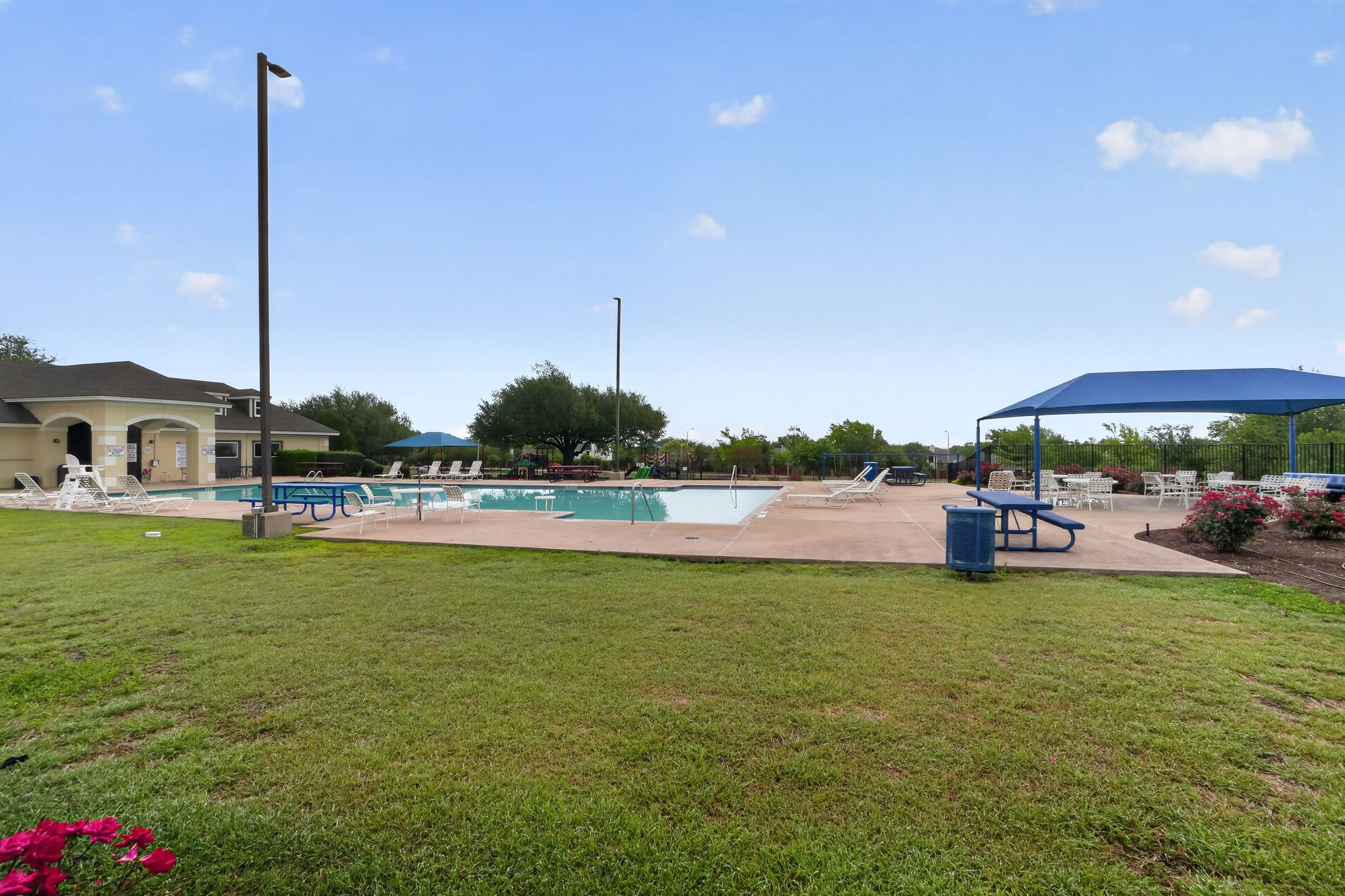 5816 Minch Road Austin, TX 78754 - Photo 15 of 15 Community amenities include a spacious pool area with lounge chairs, a covered seating area with picnic tables, and a surrounding lawn