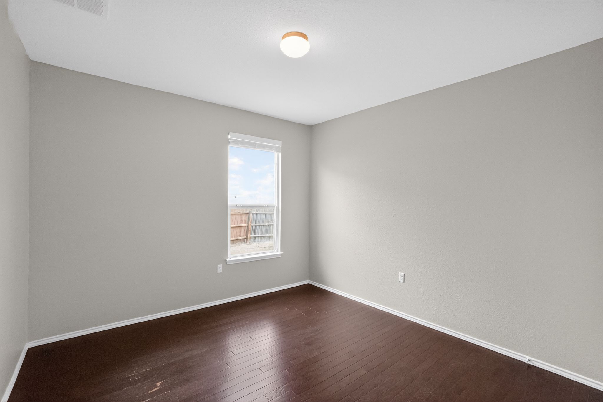 5816 Minch Road Austin, TX 78754 - Photo 2 of 15 This room features dark wood flooring, light grey walls, and a window providing natural light