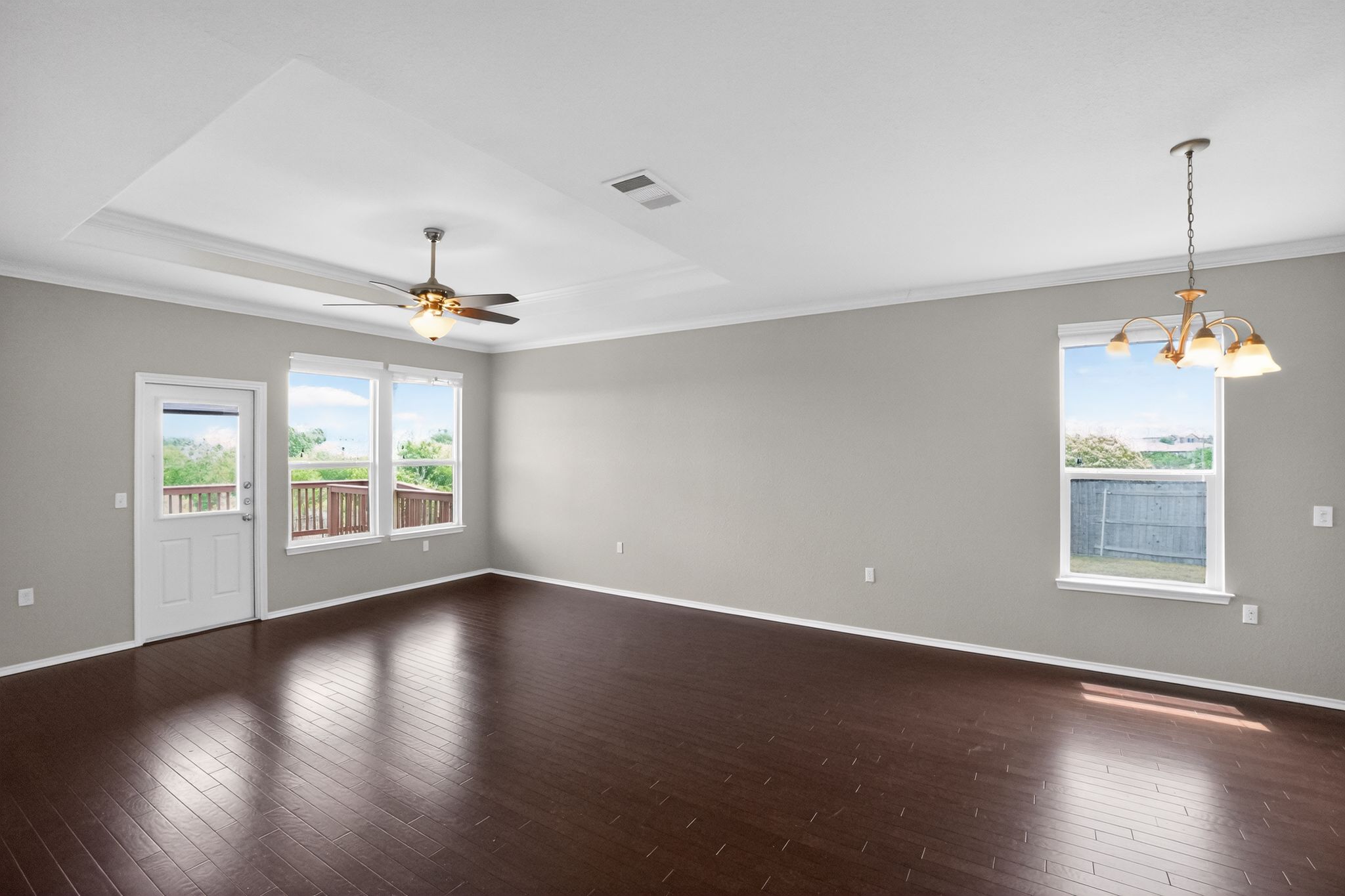 5816 Minch Road Austin, TX 78754 - Photo 3 of 15 Spacious room featuring dark wood flooring, a tray ceiling, and a ceiling fan