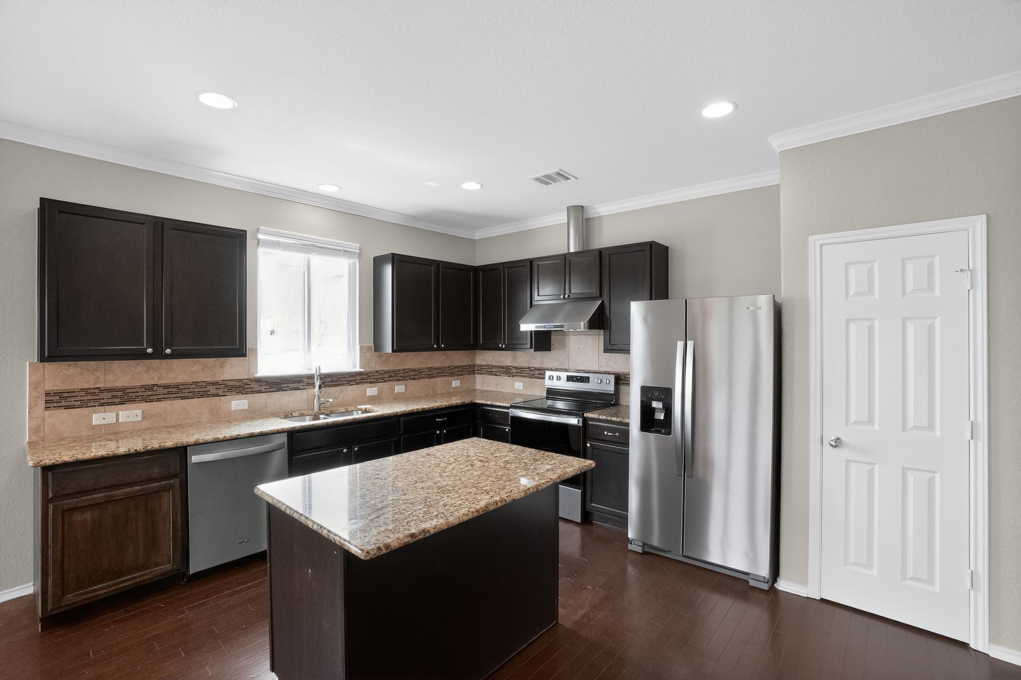 5816 Minch Road Austin, TX 78754 - Photo 7 of 15 Well-appointed kitchen featuring dark wood cabinetry, granite countertops, and stainless steel appliances, including a side-by-side refrigerator, electric range, and dishwasher