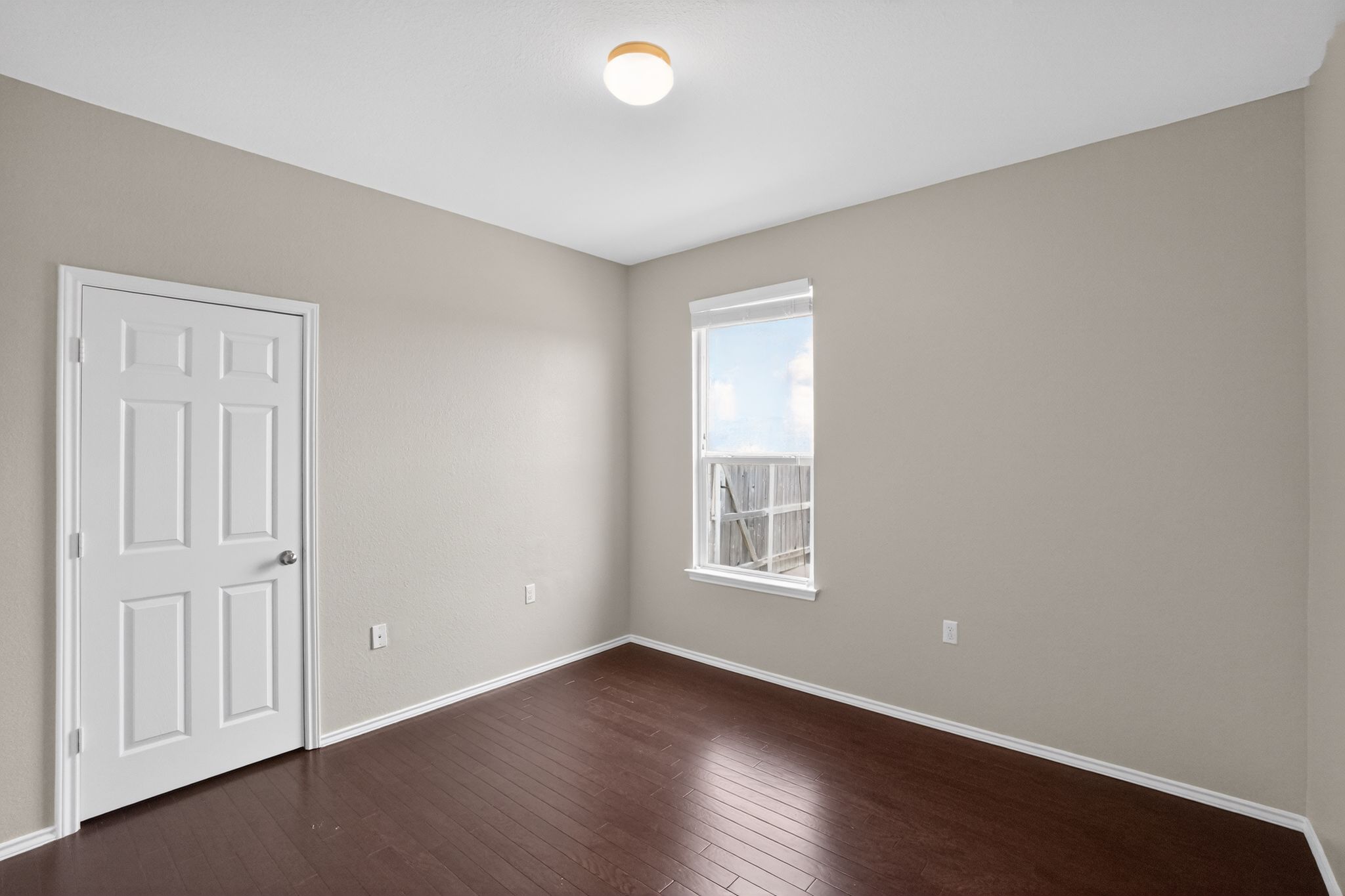5816 Minch Road Austin, TX 78754 - Photo 8 of 15 This room features dark wood flooring, light neutral walls, and a window providing natural light