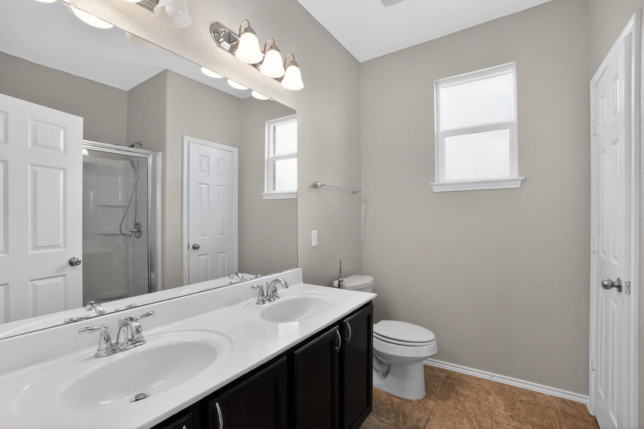 5816 Minch Road Austin, TX 78754 - Photo 9 of 15 Bathroom featuring a double vanity with white countertops, chrome fixtures, and dark cabinetry