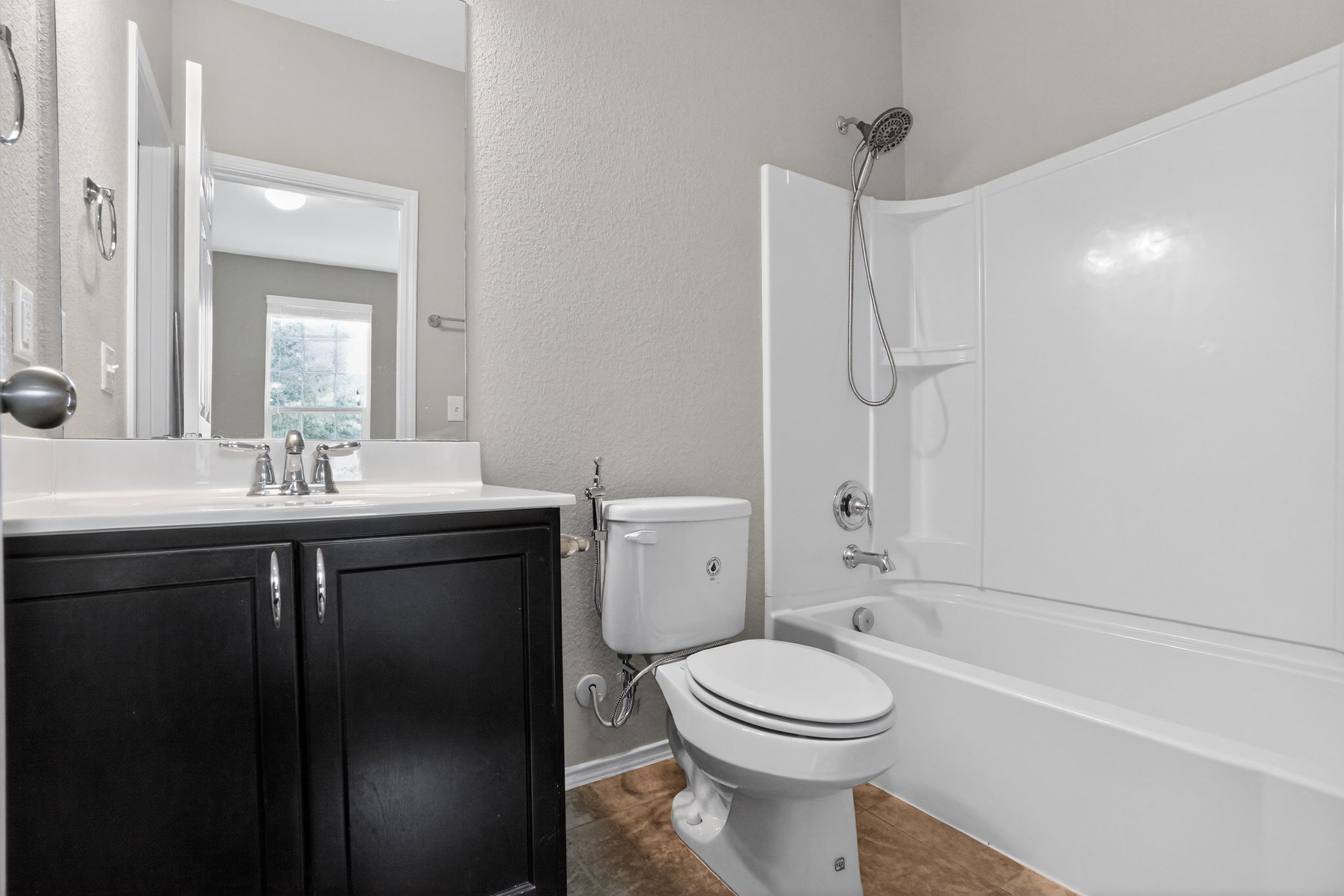 5816 Minch Road Austin, TX 78754 - Photo 10 of 15 Bathroom featuring a dark wood vanity with a white countertop, a mirror, and a white tub and shower combination