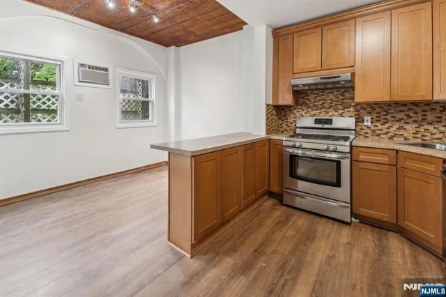 a kitchen with granite countertop wooden floors and white stainless steel appliances