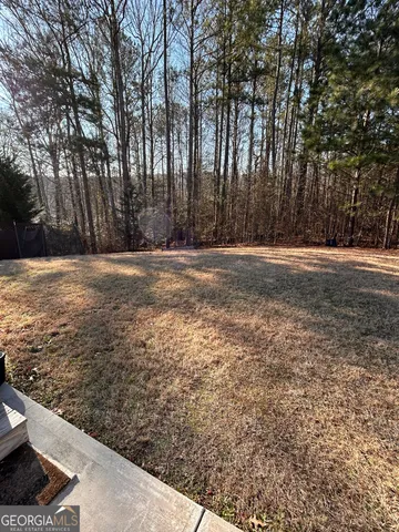 a view of a yard with large trees