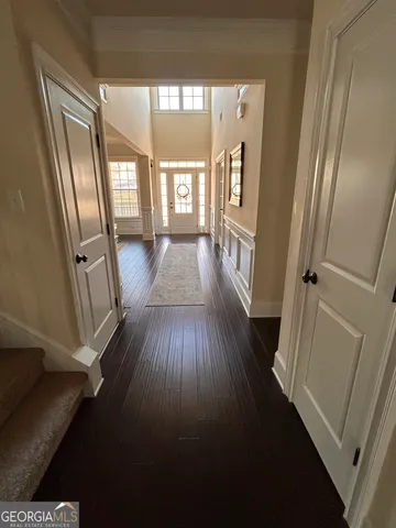 a view of a hallway with wooden floor and staircase