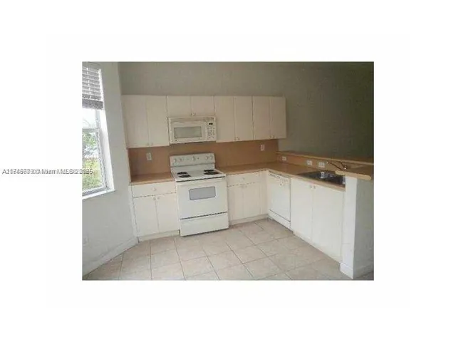 a kitchen with a cabinets and white appliances