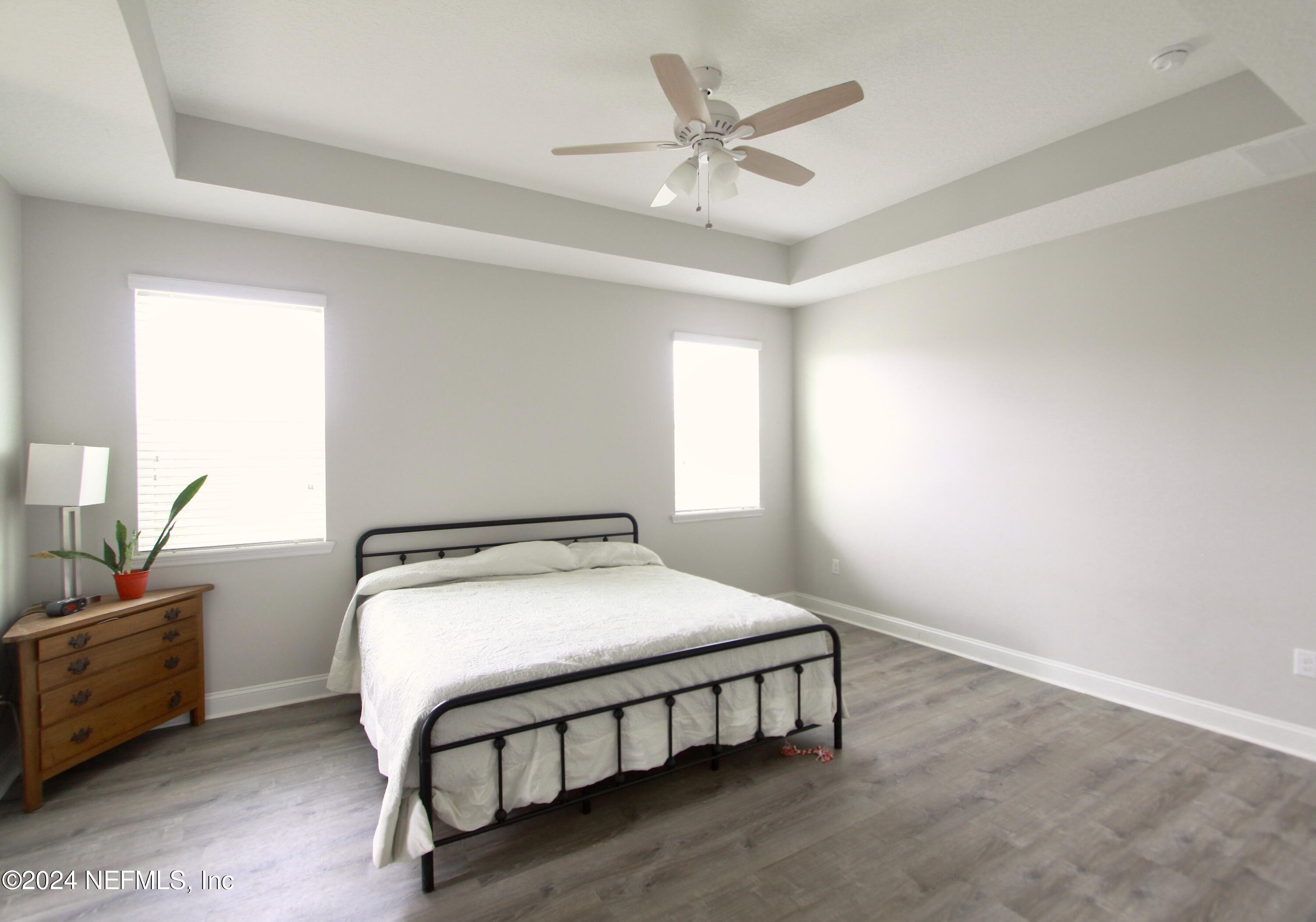 458 Convex Lane St. Augustine, FL 32095 - Photo 13 of 26 a bedroom with a bed a chandelier and a dresser