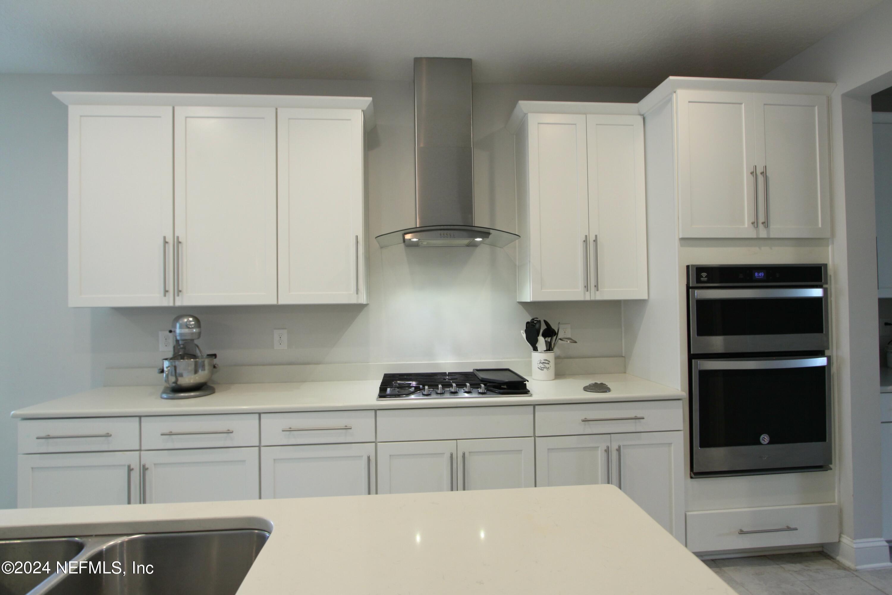 458 Convex Lane St. Augustine, FL 32095 - Photo 6 of 26 a kitchen with granite countertop white cabinets and stainless steel appliances