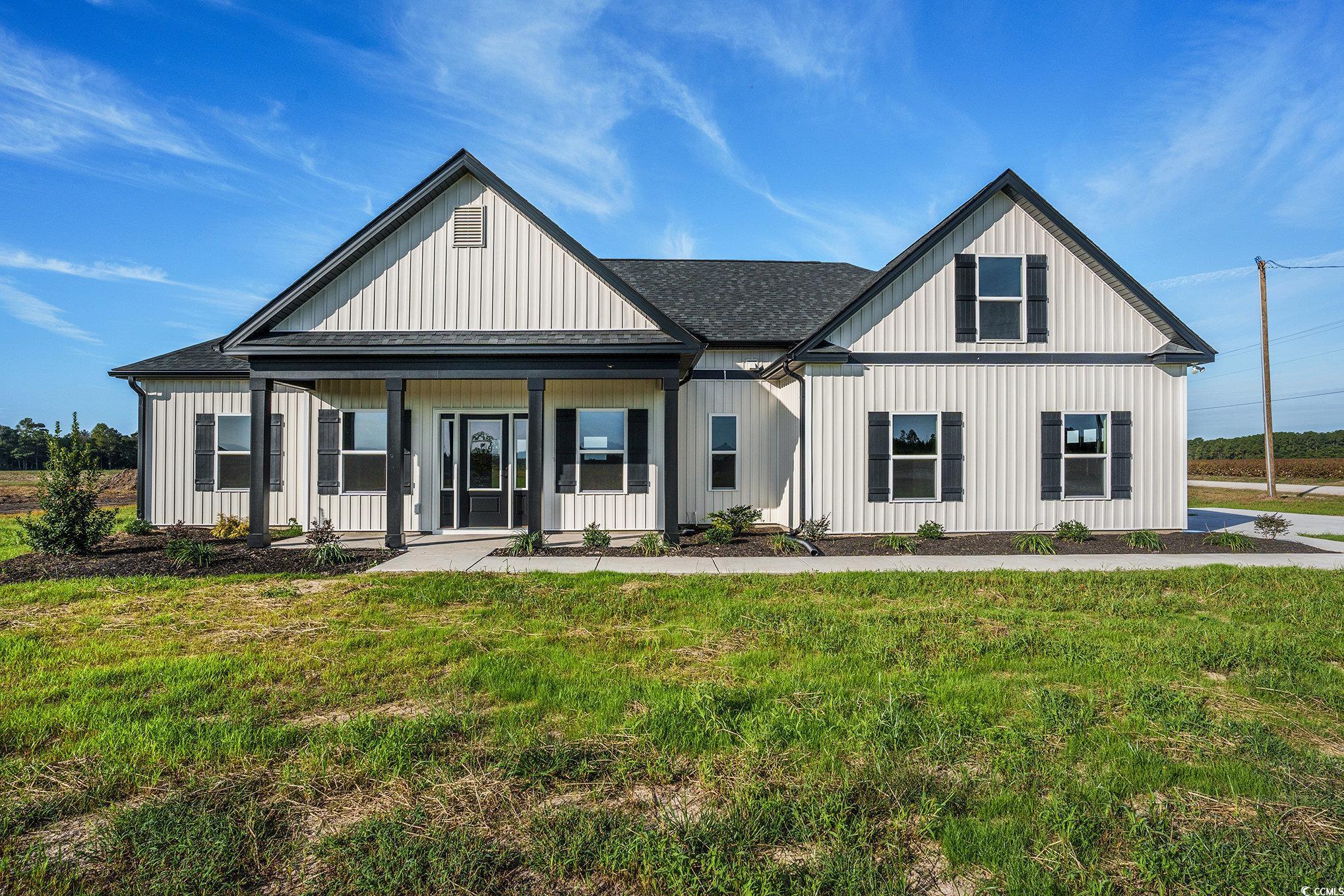 7102 Louisville Road Aynor, SC 29511 - Photo 1 of 29 Modern farmhouse style home featuring a porch, a shingled roof, and a front lawn