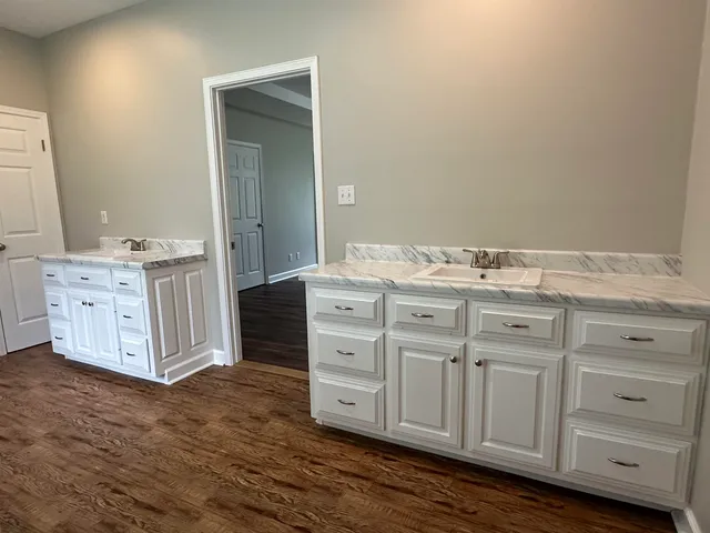 a spacious bathroom with stainless steel appliances double vanity and a mirror