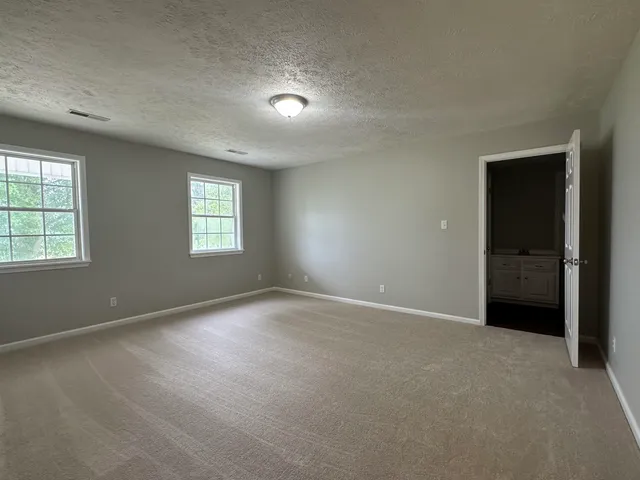 an empty room with windows and closet