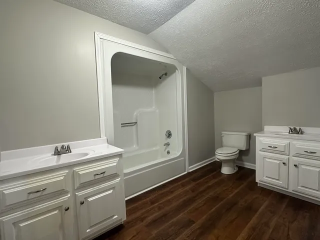 a bathroom with a granite countertop sink mirror vanity and toilet