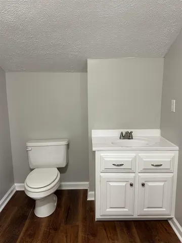 a white toilet sitting next to a white cabinet