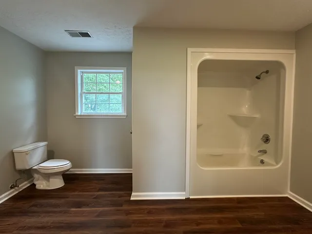 a bathroom with a toilet and a shower