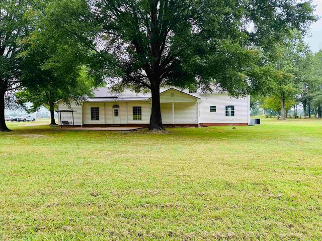 a view of a house with yard and sitting area
